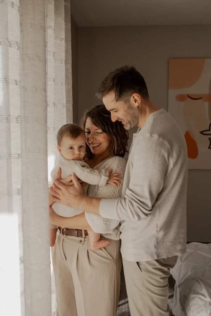 Photo de famille avec un nouveau-né dans le salon – ambiance douce et naturelle.